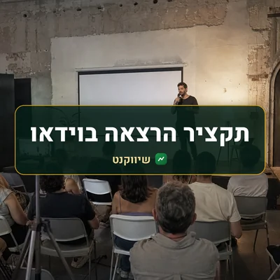 תקציר הרצאה בוידאו: מרצה על במה קטנה מול קהל, וטלפון על חצובה מתעד את ההרצאה